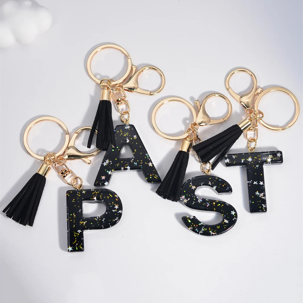 Glitter resin initial letter keychain with a star and tassel